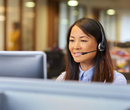 women on computer wearing a headset